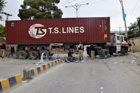 Police officers guard a road blocked by a shipping container and truck in Quetta, the capital of Balochistan province in Pakistan, July 29, 2024.