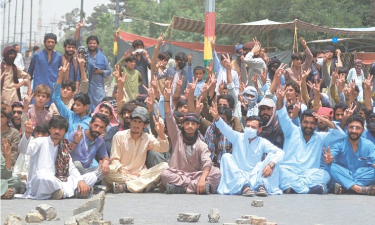 QUETTA: Baloch Yakjehti Committee supporters stage a sit-in on Sariab Road, in front of the Balochistan University, on Wednesday.—Adnan Ahmed